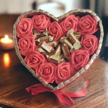 Toblerone minis amandel op een hart omringt door rode foam rozen. Hart zelf omringt door Merci chocolaatjes