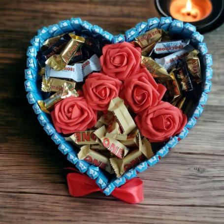 Toblerone mix en Toblerone amandel op een hart met 6 rozen. Hart is omringt met chocolaatjes huismerk.