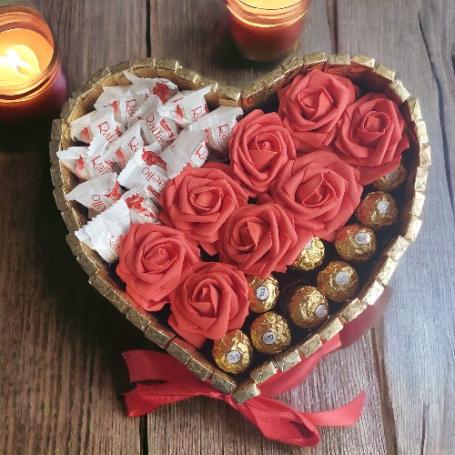 Een hart met een deel Ferrero Rocher, een deel Raffaellos en in het midden een strook rode foam rozen