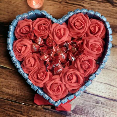 Hart met Malteser bonbons omringt met rode rozen. Het hart is omringt met chocolaatjes huismerk