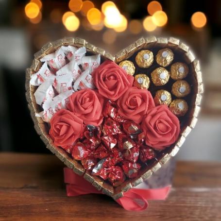 Een hart met links Raffaellos, recht van het hart Ferrero Rocher en oner Maltesers, rode rozen