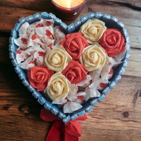 Raffaellos op een hart met in het midden 3 roden rozen omringt met chocolaatjes cremevulling
