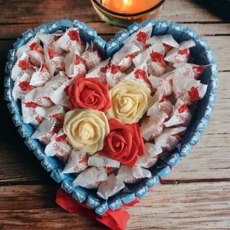 Raffaellos op een hart met in het midden 2 witte en 2 rode rozen. Hart is omringt met chocolaatjes huismerk