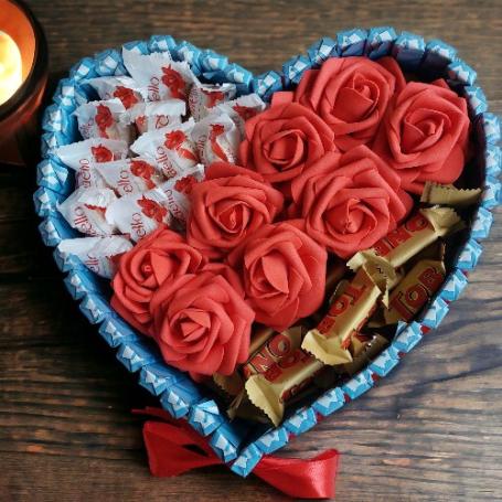 Toblerone minis en Raffaellos op een hart gescheiden door een strook rode foam rozen en omringt aan de zijkant met chocolaatj