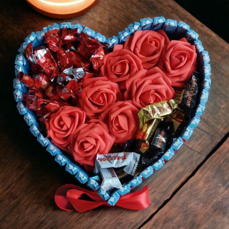 Een hart met links boven Maltesers en recht onder Toblerone mix. Bonbons zijn gescheiden door een strook van 8 rode foam roze
